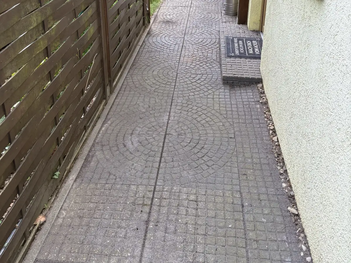 Derselbe Gartenweg nach der Unkrautentfernung – Pflaster wieder frei und begehbar